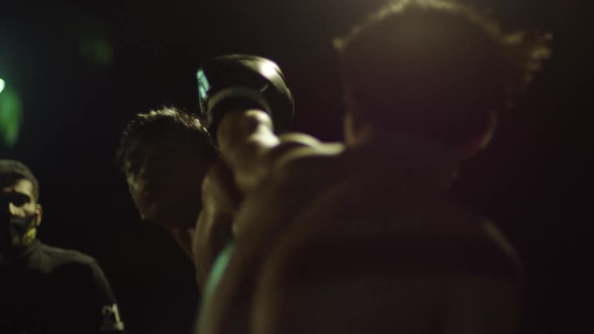 Young boxers fight on a ring at night