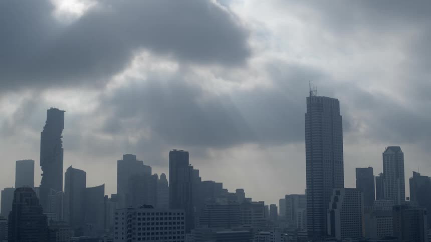 High rise buildings skyscrapers under clouds floating in the city