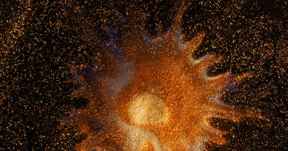 The darkness is filled with orange twinkling lights as a nebula explodes from the center opening a portal in space