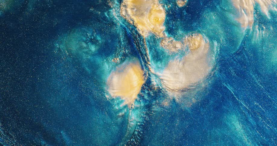 A glittery blue substance ripples and sparkles as it moves and the light yellow areas slowly blend and colors mix