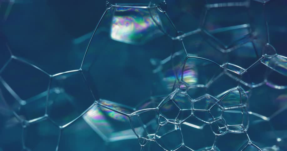 A clear bubble substance reflects color as it moves and parts connect and disconnect from their sides