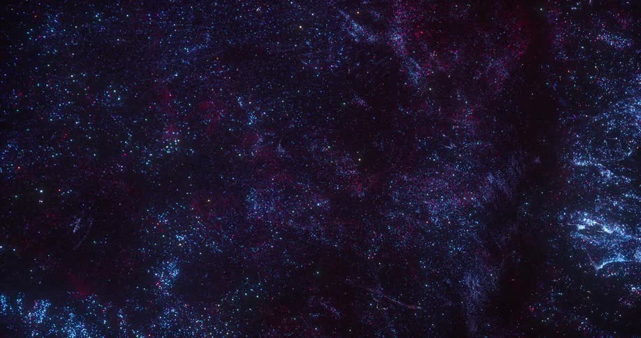 Blue and purple pinpoints of light glitter like stars in the darkness moving in rippling space