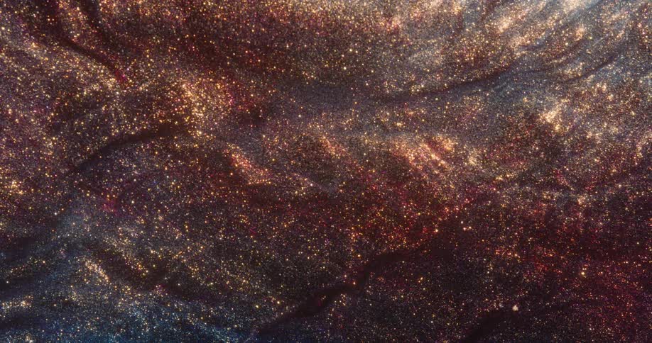 Red and orange pinpoints of light glitter like stars in the darkness as the environment ripples