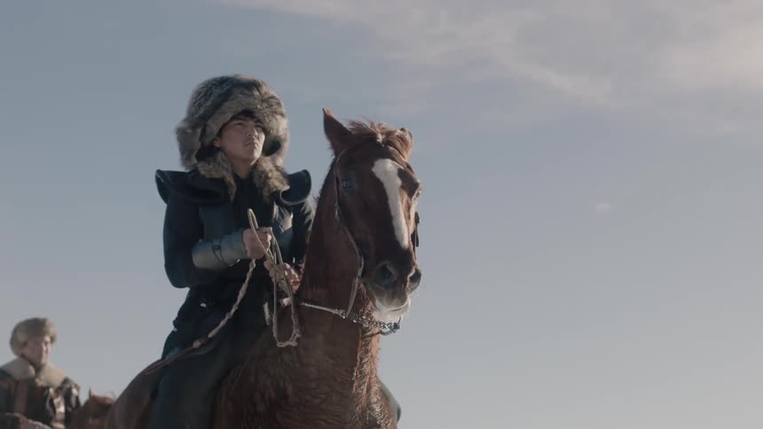People are riding horses on a windy day