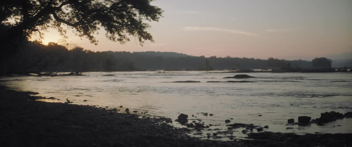 Water flowing towards a lakefront beach at sunset