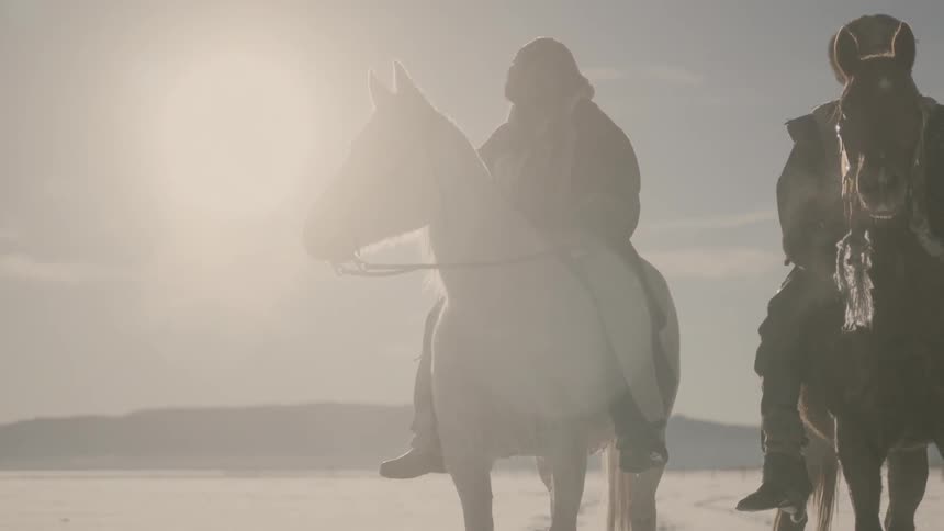 People are sitting on horses on a snow field