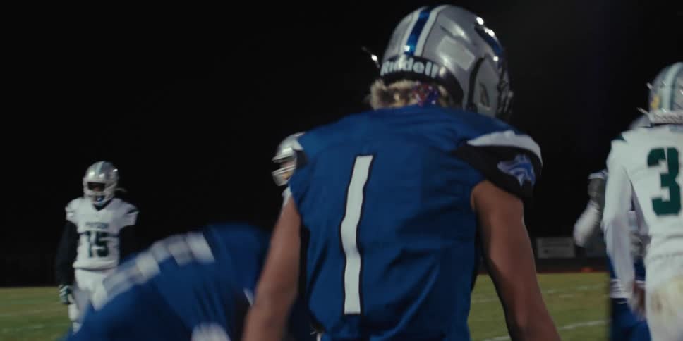 A teenager congratulates a teammate for a play during a football game