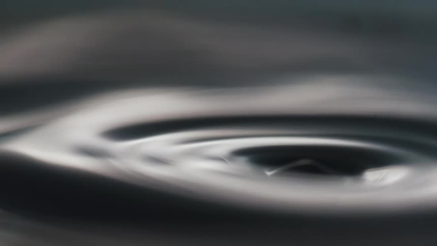 A drop of water falls and splashes