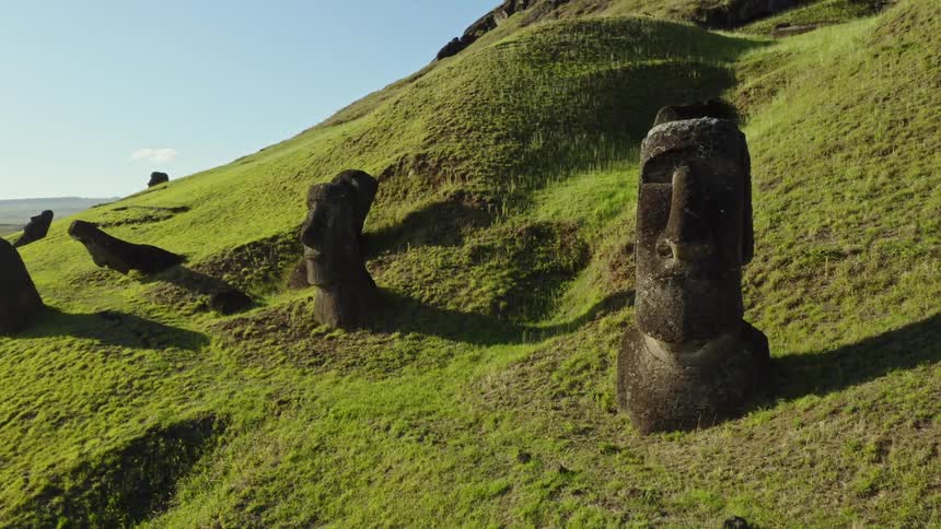 The moai statues on easter island on a bright green hill on a sunny day
