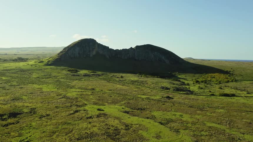 An aerial view of a mountain surrounded by fields in nature