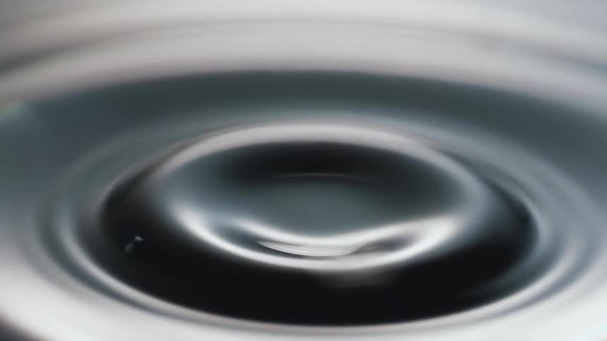 Water ripples outward as a droplet falls in
