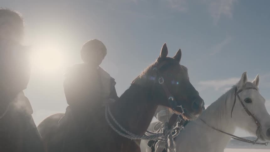 Men wearing heavy clothing sits atop their horses