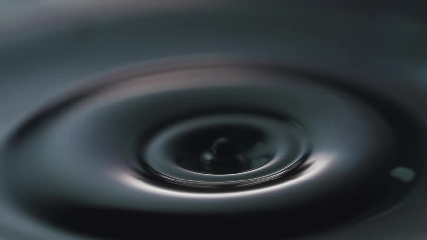 A droplet falling into a body of water and causing ripples