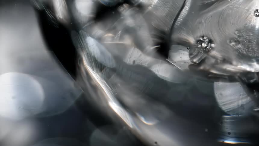 Bubbles are floating in a liquid and reflect light as they move