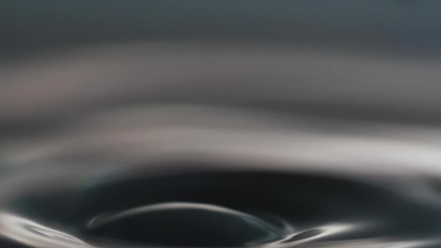 A droplet falling into a body of water and causing ripples