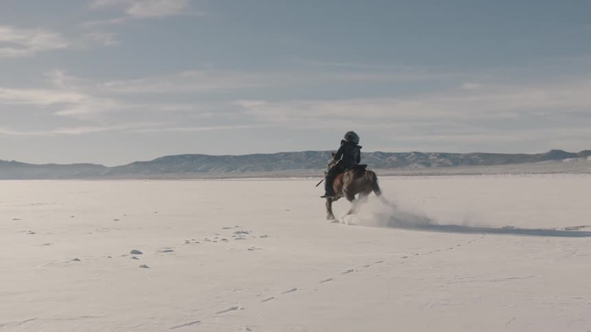 A man races his horse in the snow