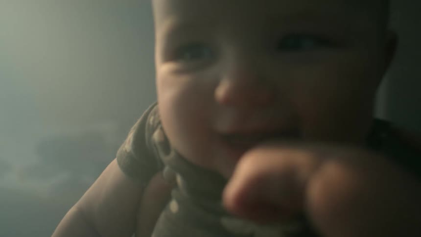 Mother holds up baby laughing