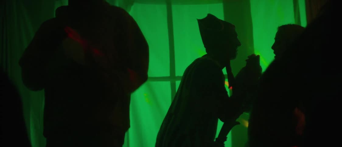 People are dancing and having fun in a green lit room