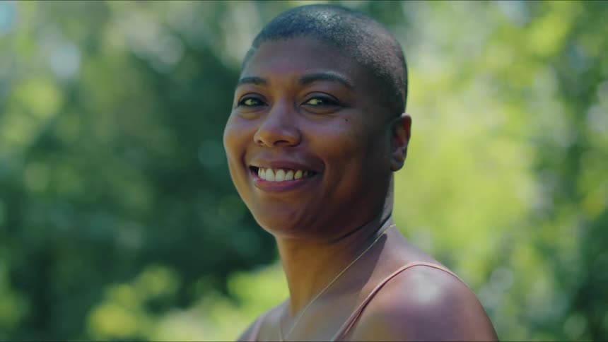 Woman standing outdoors turns with a smile