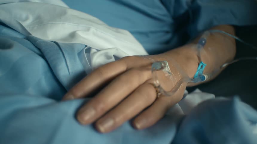 A patient with an iv lying in a hospital bed