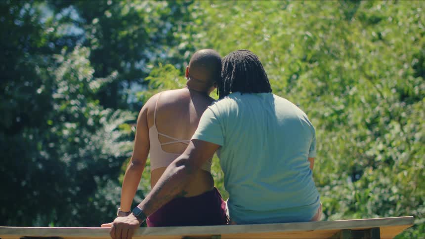 A couple is sitting close together as they look at the trees