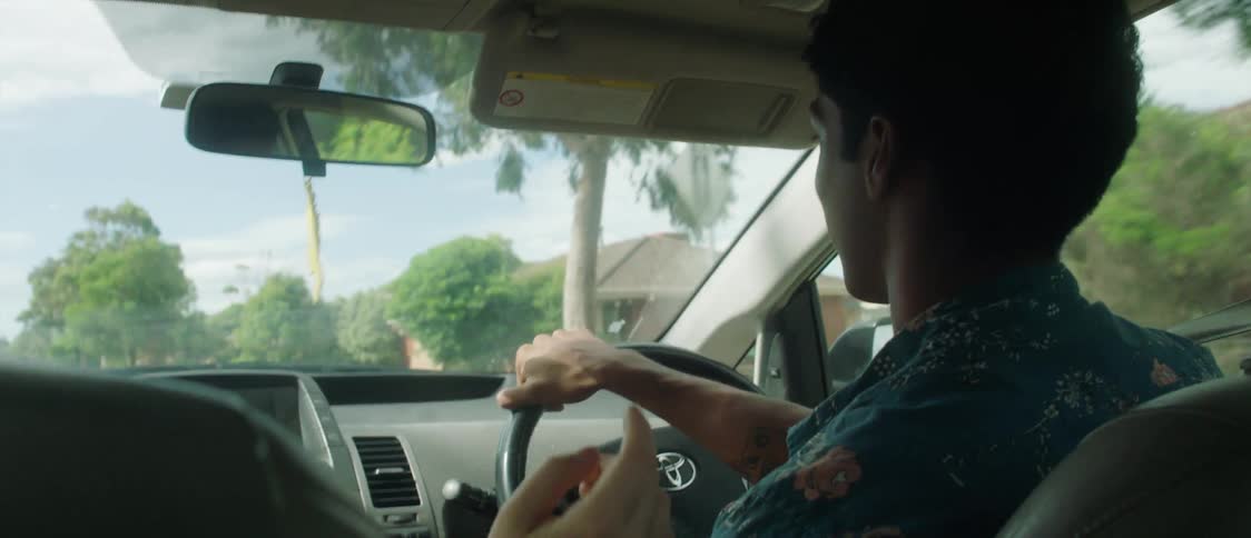 Blonde woman talking to man with blue shirt driving car in the city street