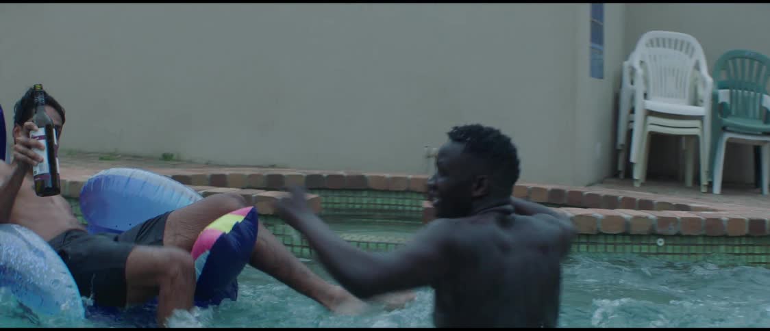 Friends playfully chase each other in a shallow pool on the backyard