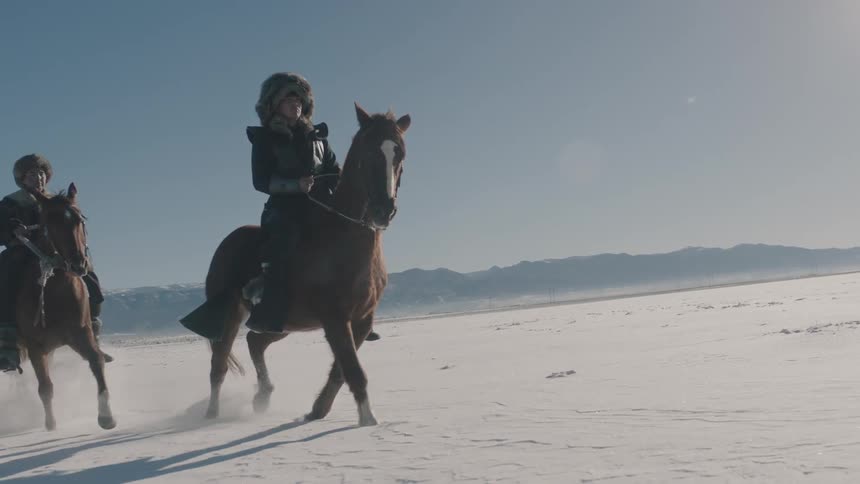Two people on horses run on the snow