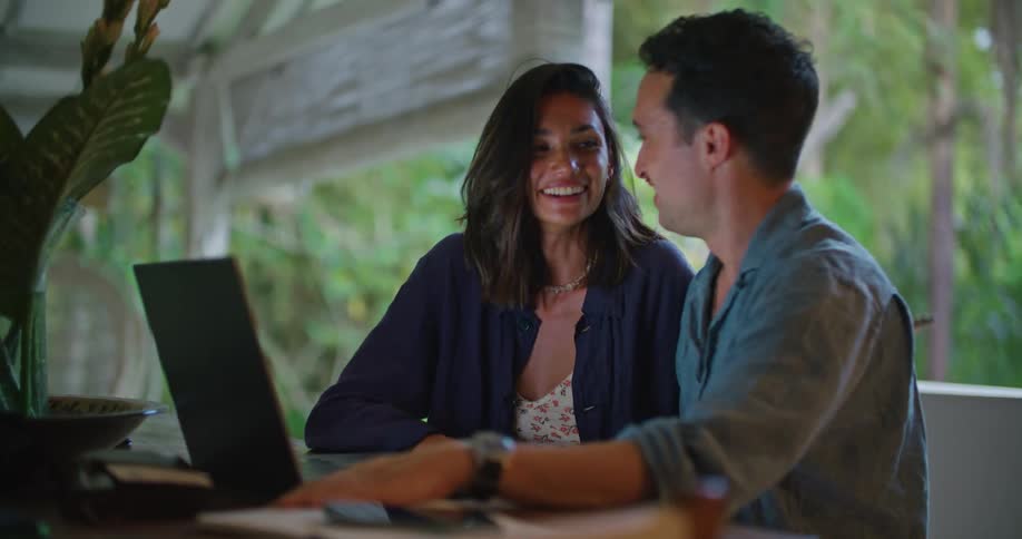 A man and woman talk with someone on the laptop