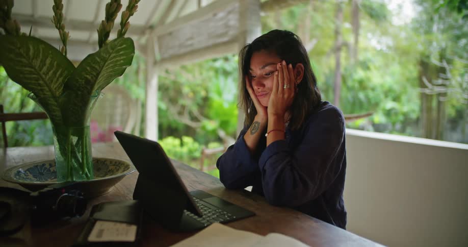 A woman is typing on her tablet