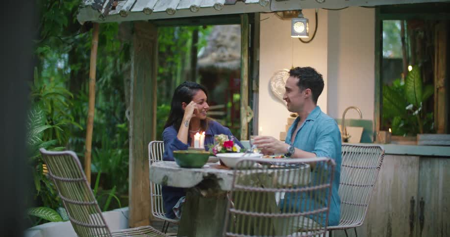 Young happy couple eating a meal in the backyard talking and laughing