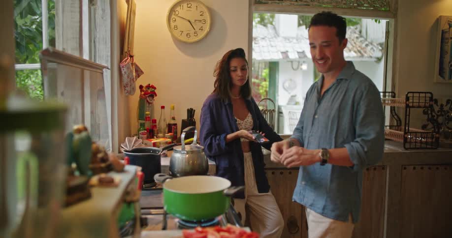 Young happy couple talk while cooking a homemade meal in the kitchen