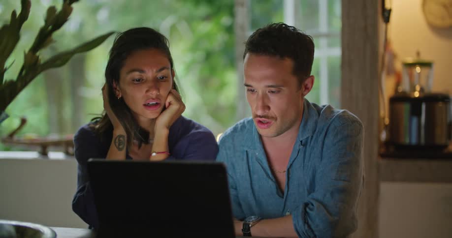 Young couple sitting in the dinning room browsing on a laptop