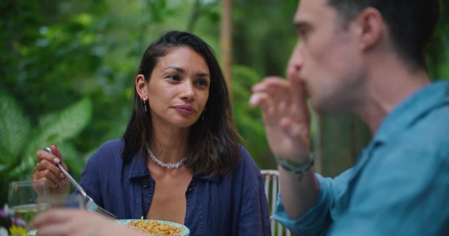 Man and woman smile and talk while eating outdoors
