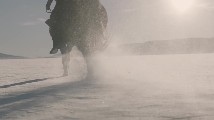 A person is racing a horse on a snow covered field