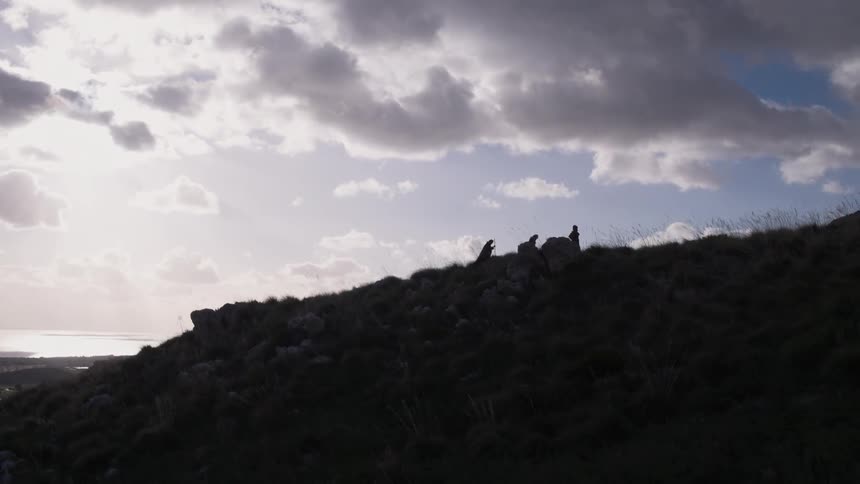 People are hiking uphill on a cloudy day
