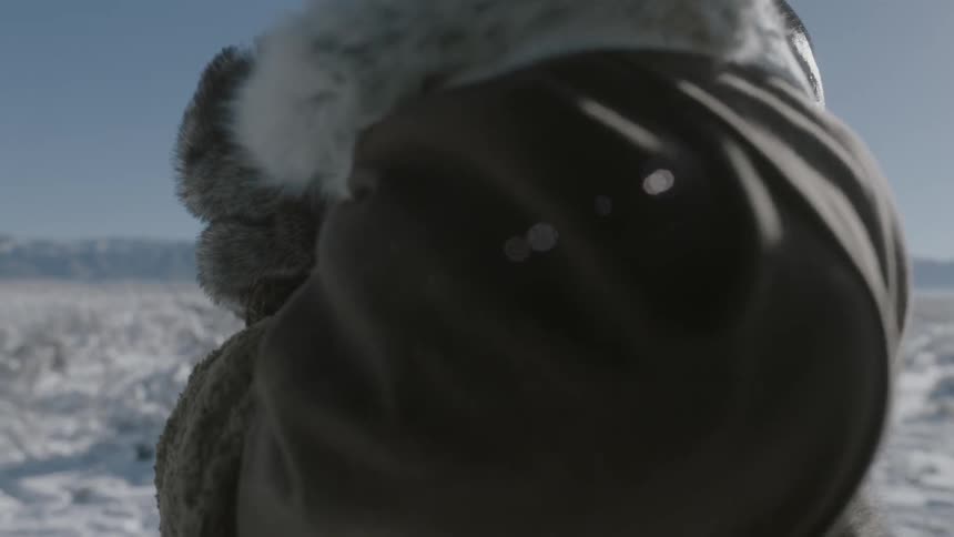 A man puts his hood up on a windy day