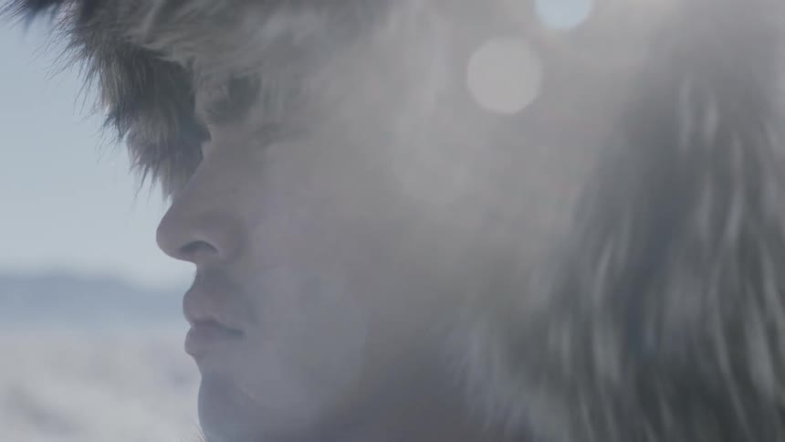 Man wearing fur hat looks into the distance