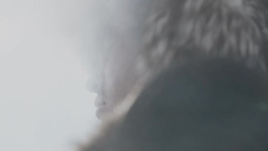 A man in a fur hat stands on a cold day