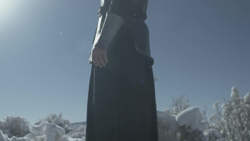 A person is standing in the snow on a sunny day