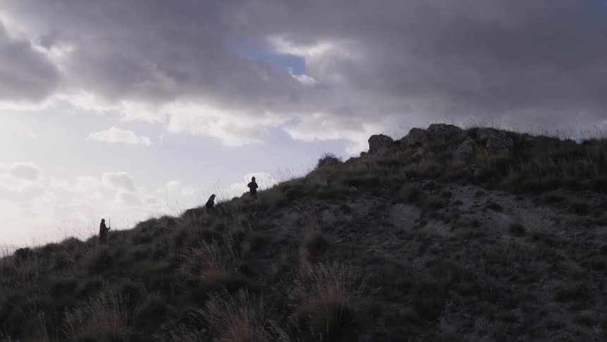 People are hiking up a steep hill