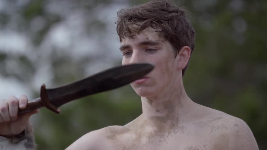 A man removing a short sword from its sheath