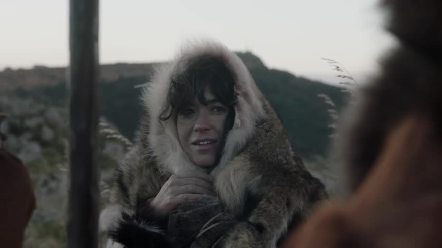 People wearing furs are outside on a windy day