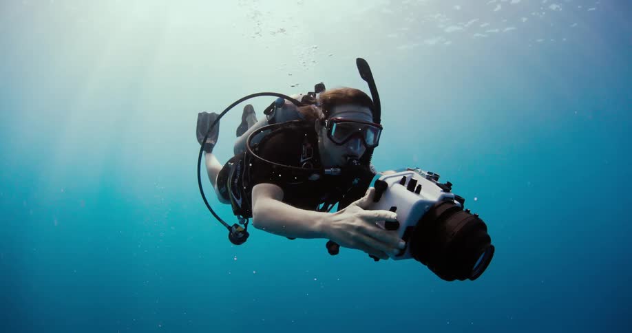 A diver records video in the ocean