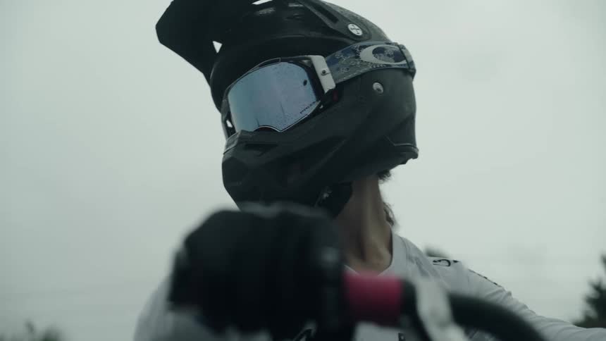 A person is wearing a motorcycle helmet on a bike