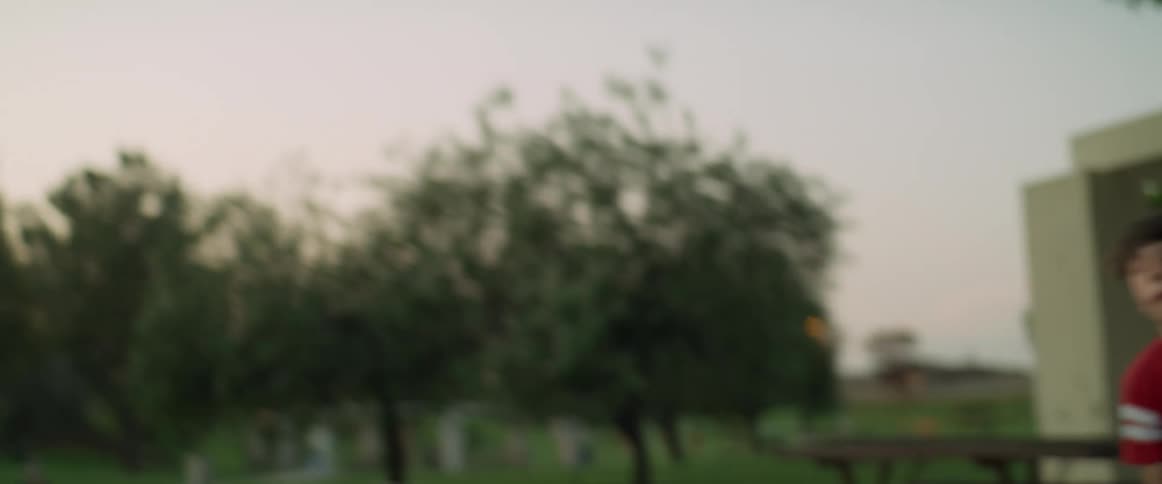 A father and son throw a football in the park