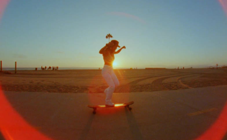 A female skateboards as the sun sets