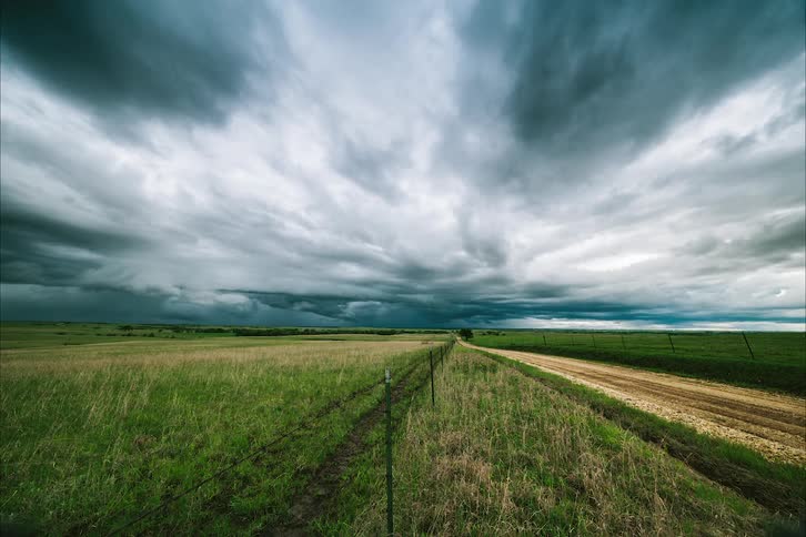 Storm clouds passing over a rural field during a summer rainstorm