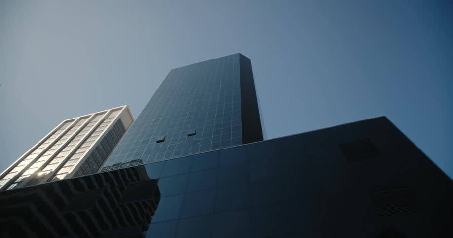 City skyscrapers towering overhead on a sunny clear day