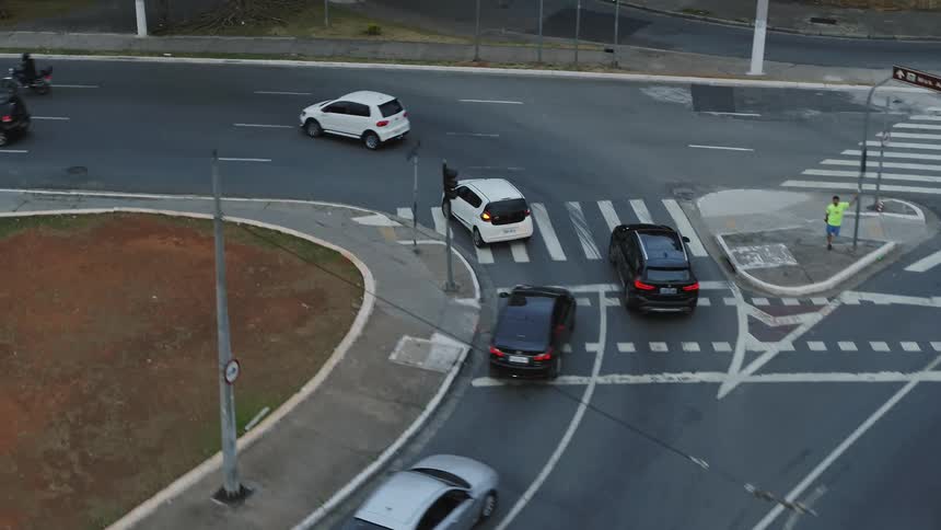 A car is driving erratically in traffic in a downtown area